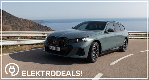 "Dreiviertel-Vorderansicht eines graugrünen BMW i5 Touring Elektro-Kombis mit Kennzeichen 'MDI 380E', parkend auf einer Küstenstraße. Mit 'Elektrodeals!'-Logo."