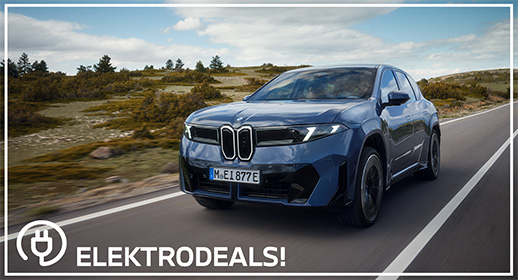 Dreiviertel-Vorderansicht eines blauen BMW iX Elektro-SUVs mit Kennzeichen 'MEI 877E', der auf einer Straße durch eine Heidelandschaft fährt. Mit 'Elektrodeals!'-Logo."