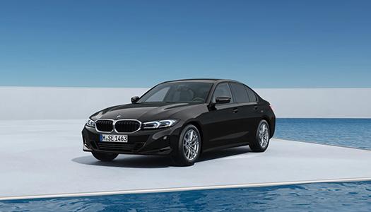 BMW 3er Limousine Aktionsangebot Ausstattung Schwarze BMW 318i Limousine auf einer weißen Plattform neben einem Wasserbecken unter blauem Himmel. Das Bild präsentiert das spezifische Modell des Angebots in einer stilvollen Umgebung.