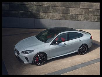 Die Profilaufnahme des BMW M235 xDrive Gran Coupé betont die fließende Coupé-Dachlinie, die markanten Seitenschweller und die sportlichen M-Leichtmetallräder in einer kontrastreichen Umgebung.