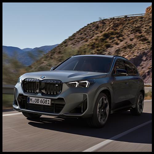 Ein grauer BMW X1 M35i in Fahrt; man sieht die sportliche Silhouette, große Leichtmetallfelgen und die aggressive Frontpartie.