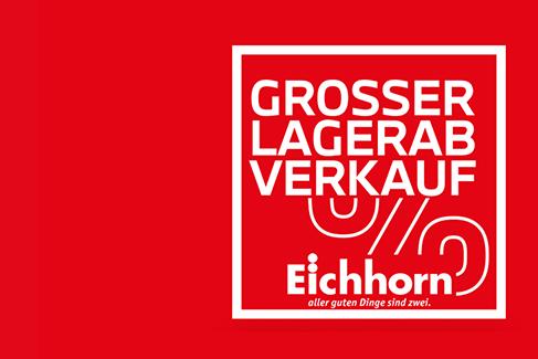 Das Bild ist ebenfalls eine Werbegrafik mit einem leuchtend roten Hintergrund. Ein weißes Quadrat auf der rechten Seite enthält den Text „GROSSER LAGERAB VERKAUF“ in weißen Großbuchstaben. Darunter sind weiße, abstrakte, geschwungene Linien gezeichnet. Am unteren Rand des Quadrats steht in etwas größerer weißer Schrift das Wort „Eichhorn“, und darunter, in kleinerer weißer Schrift, der Slogan „aller guten Dinge sind zwei.“ Die gesamte Grafik hat einen klaren, werbenden Look.
