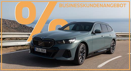 Das Bild zeigt einen graugrünen BMW i5 Touring auf einer Straße an der Küste. Oben im Bild steht der Text „GEWERBEKUNDENANGEBOT“, und links ist ein großes, oranges Prozentsymbol zu sehen. Ein orangefarbener Rahmen umgibt das gesamte Bild.