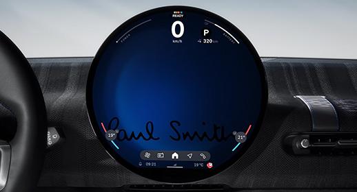 Das runde OLED-Zentraldisplay im Cockpit der MINI Paul Smith Edition mit digitaler Geschwindigkeitsanzeige und dem exklusiven, eingeblendeten Paul Smith Schriftzug auf blauem Hintergrund.
