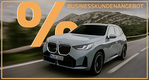 Das Bild zeigt einen hellgrauen BMW X3 auf einer Straße, die durch eine bergige Landschaft führt. Oben im Bild steht der Text „GEWERBEKUNDENANGEBOT“ und links ist ein großes, oranges Prozentsymbol zu sehen. Ein orangefarbener Rahmen umgibt das gesamte Bild.