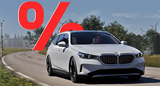 Das Bild zeigt ein weißes, viertüriges SUV der BMW 5er-Reihe Touring, das auf einer Landstraße fährt. Das Auto ist schräg von vorne zu sehen. Im Vordergrund ist ein großes, rotes Prozentzeichen (%) platziert. Der Hintergrund zeigt eine bergige Landschaft mit Windrädern unter einem blauen Himmel.